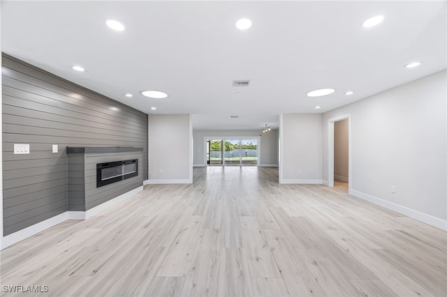 unfurnished living room with a fireplace, recessed lighting, visible vents, light wood-style flooring, and baseboards