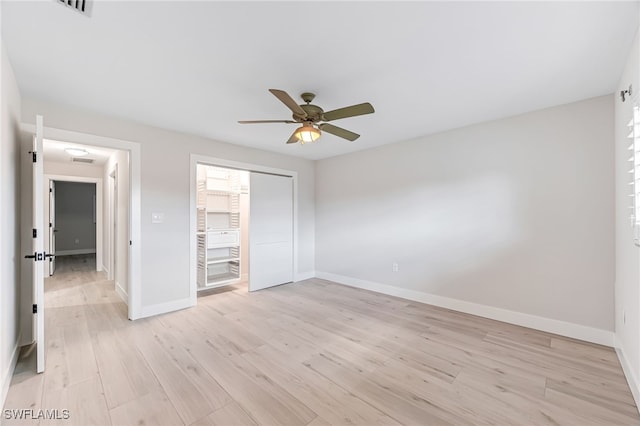 unfurnished bedroom featuring a ceiling fan, light wood-type flooring, a closet, and baseboards