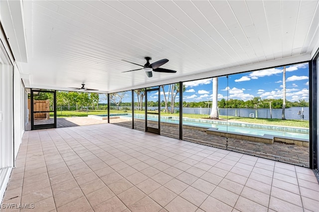 unfurnished sunroom featuring a ceiling fan