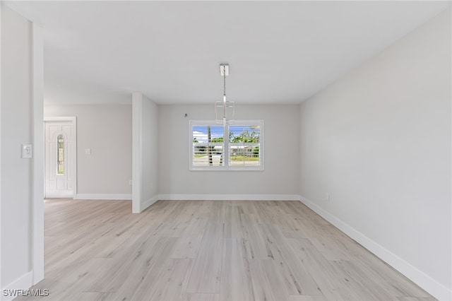 unfurnished dining area with light wood-type flooring and baseboards