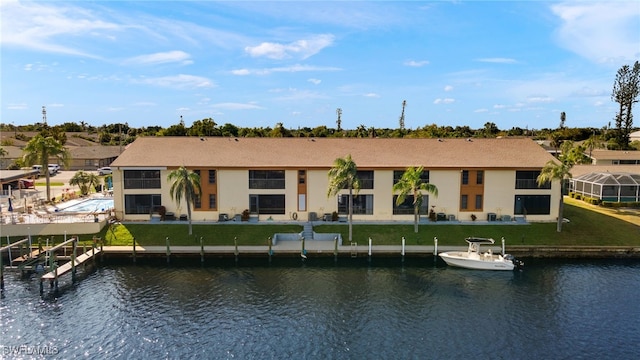 back of house featuring a water view and a lawn