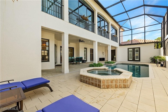 exterior space with a balcony, a patio, french doors, and stucco siding