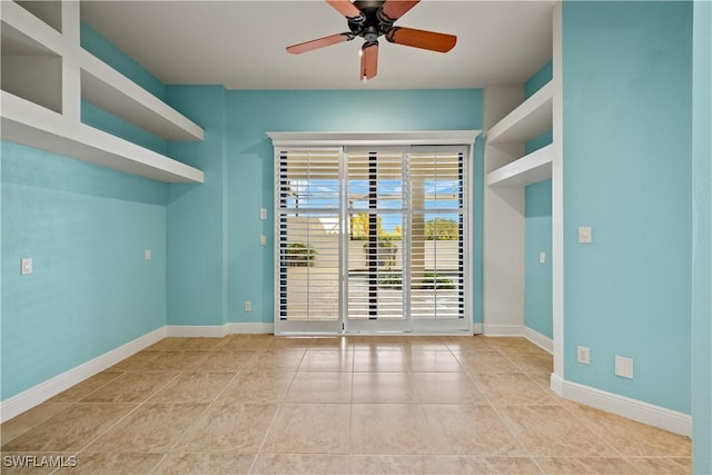 tiled spare room featuring ceiling fan and baseboards