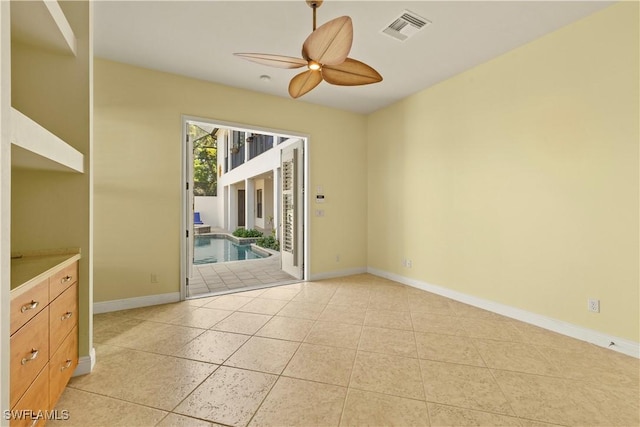 empty room featuring light tile patterned floors, visible vents, and baseboards