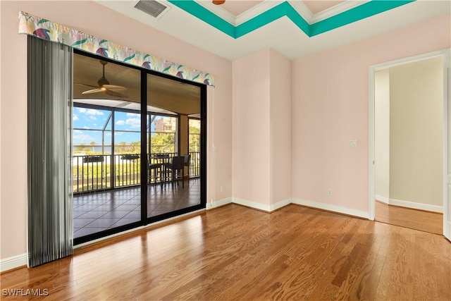 empty room featuring baseboards, ceiling fan, visible vents, and wood finished floors