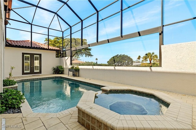 view of pool with glass enclosure, french doors, a patio, and a pool with connected hot tub