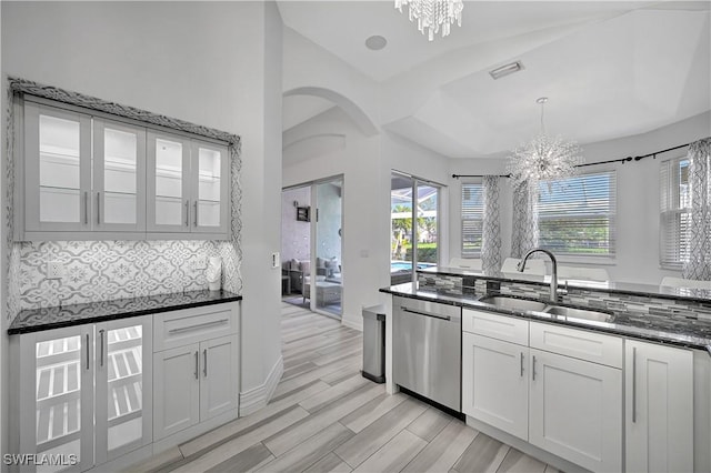 kitchen featuring dishwasher, white cabinetry, glass insert cabinets, and a sink