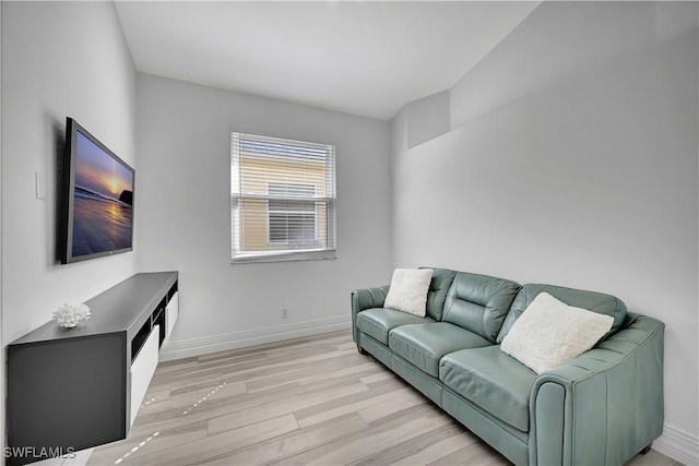 living area with light wood-style flooring and baseboards