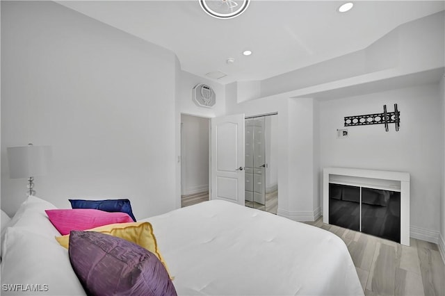 bedroom with baseboards, light wood finished floors, and recessed lighting