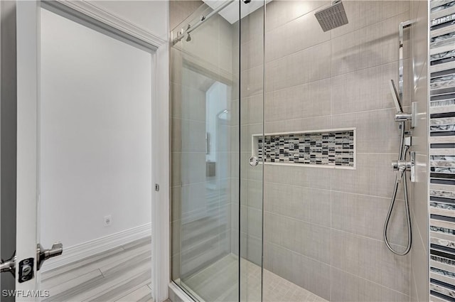 bathroom featuring a stall shower, wood finished floors, and baseboards