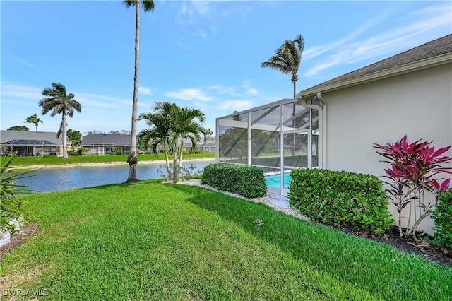 view of yard with a lanai and a water view