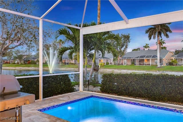 view of pool with a water view and glass enclosure