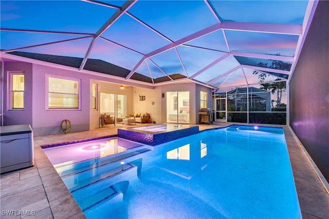 pool at dusk featuring a patio, glass enclosure, a jacuzzi, an outdoor pool, and an outdoor living space