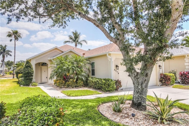 8074 Tauren Ct, Naples, FL 34119 - mediterranean / spanish home with a front lawn, roof with shingles, stucco siding, concrete driveway, and an attached garage