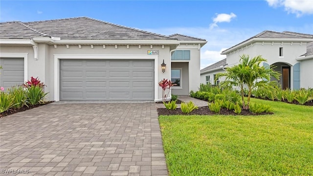 4640 Skysail Dr, Naples, FL 34120 - view of front of house featuring a front yard, a garage, decorative driveway, and stucco siding