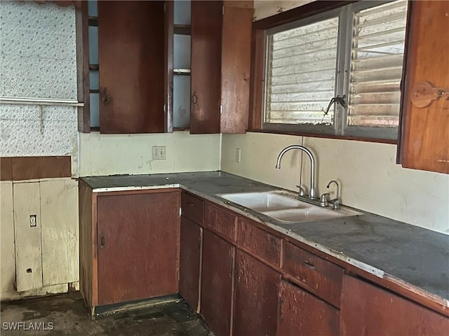 kitchen with open shelves, dark countertops, and a sink