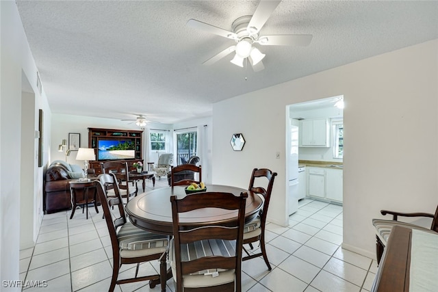 dining room featuring ceiling fan, a textured ceiling, and light tile patterned floors