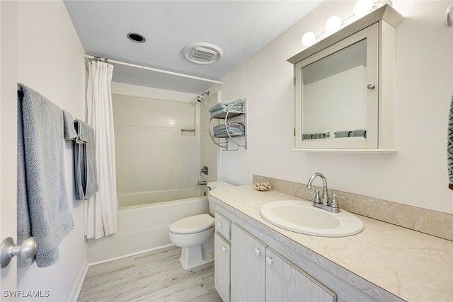 bathroom featuring toilet, wood finished floors, vanity, visible vents, and shower / bath combination with curtain