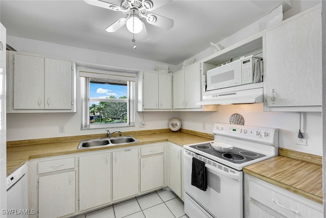 kitchen with white appliances, under cabinet range hood, light countertops, and a sink