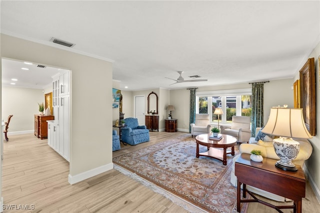 living area featuring visible vents, baseboards, crown molding, and light wood finished floors