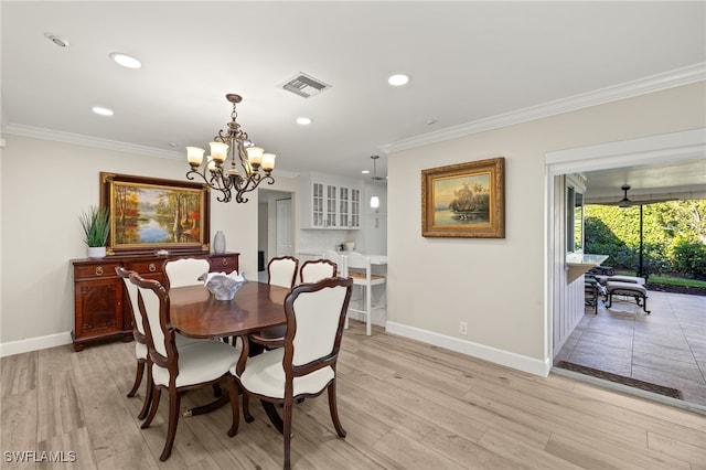 dining room featuring light wood-type flooring, baseboards, visible vents, and ornamental molding