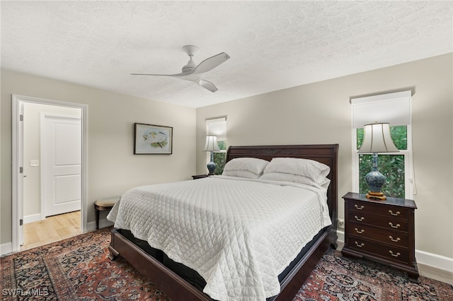 bedroom with a textured ceiling, ceiling fan, and wood finished floors