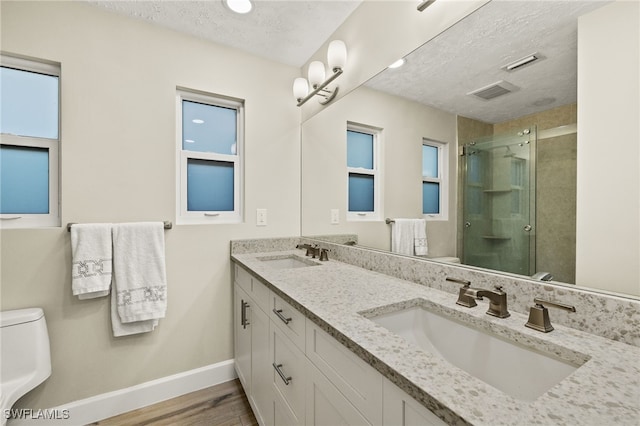 1525 Osprey Ave, Naples, FL 34102 - full bath with a textured ceiling, double vanity, a shower stall, and wood finished floors
