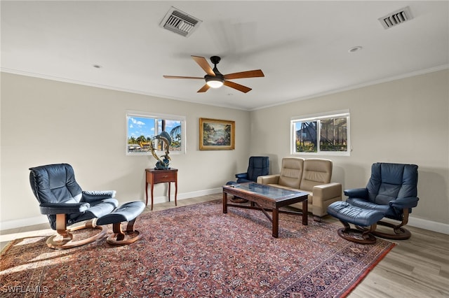 living area featuring visible vents, a healthy amount of sunlight, and ornamental molding