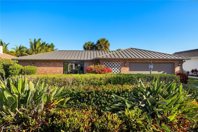 1525 Osprey Ave, Naples, FL 34102 - single story home with brick siding, a garage, and a standing seam roof