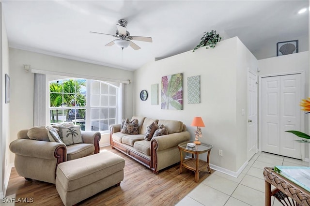 living room featuring a ceiling fan, light wood-style flooring, and baseboards