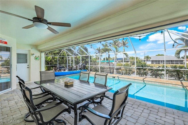 pool featuring a lanai, a patio area, and ceiling fan