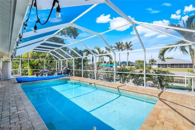 view of swimming pool featuring a lanai, a patio area, and a covered pool