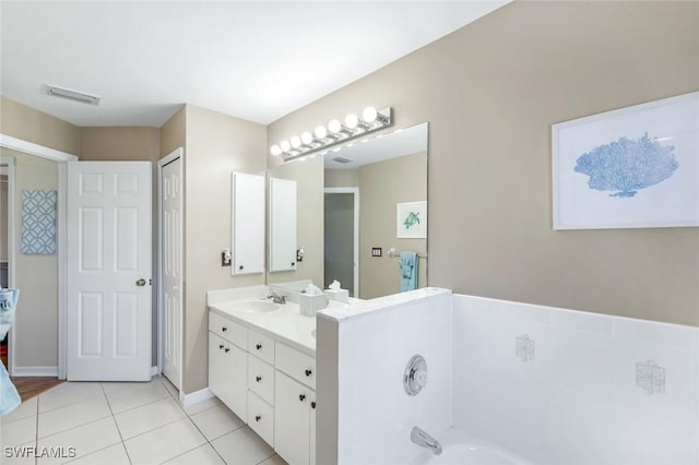 full bathroom featuring a tub to relax in, tile patterned flooring, vanity, visible vents, and baseboards