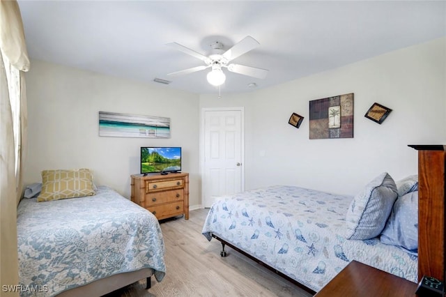 bedroom with light wood-style floors, ceiling fan, and visible vents