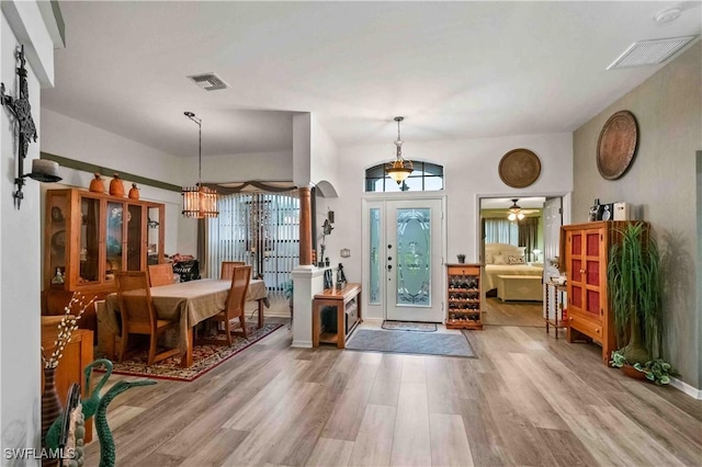 entrance foyer featuring a chandelier, visible vents, baseboards, and wood finished floors