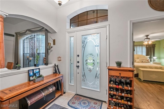 entryway featuring wood finished floors, arched walkways, and ceiling fan