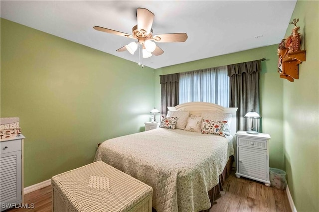 bedroom with ceiling fan, baseboards, and wood finished floors