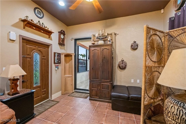 entryway featuring tile patterned flooring, a ceiling fan, and baseboards