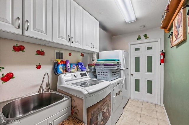 laundry room featuring separate washer and dryer, light tile patterned floors, cabinet space, and a sink