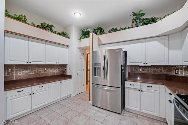 2725 SW 28th Pl, Cape Coral, FL 33914 - kitchen with appliances with stainless steel finishes, dark countertops, light tile patterned flooring, and white cabinets