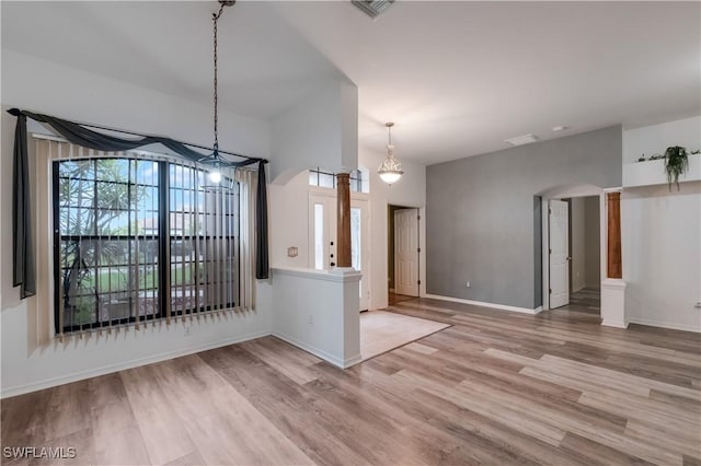 2725 SW 28th Pl, Cape Coral, FL 33914 - unfurnished dining area featuring arched walkways, light wood-type flooring, baseboards, and a chandelier