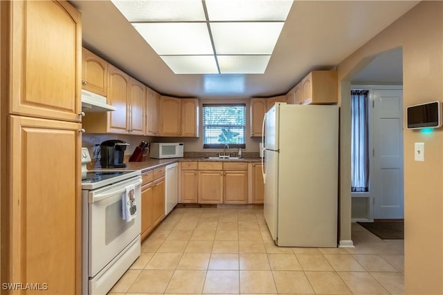 kitchen featuring light brown cabinetry, under cabinet range hood, light tile patterned flooring, white appliances, and a sink