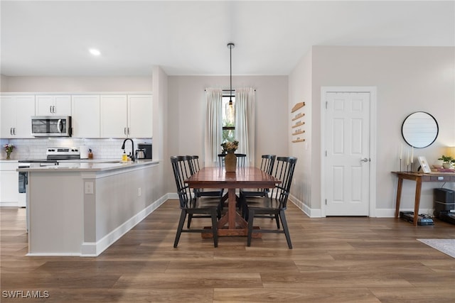 dining space featuring wood finished floors and baseboards