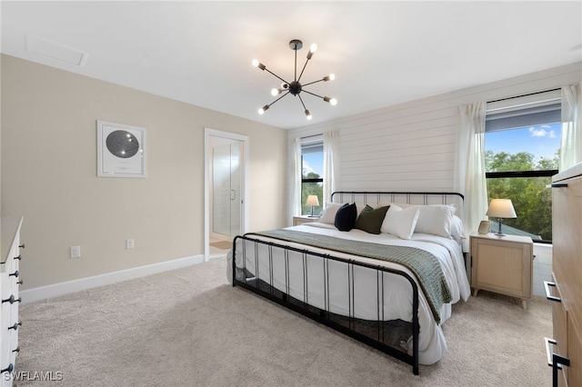 bedroom with an inviting chandelier, baseboards, and light carpet