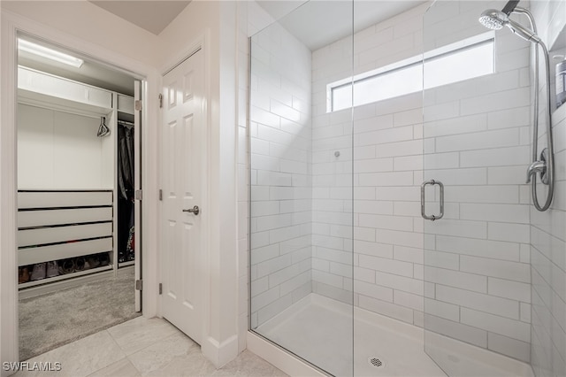 bathroom featuring a walk in closet and a stall shower