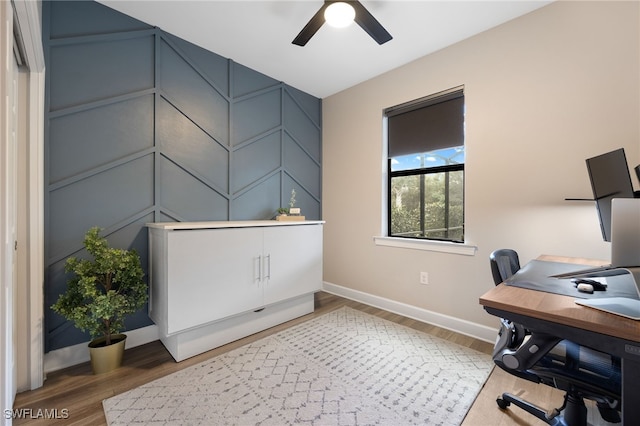 office space featuring a ceiling fan, wood finished floors, and baseboards