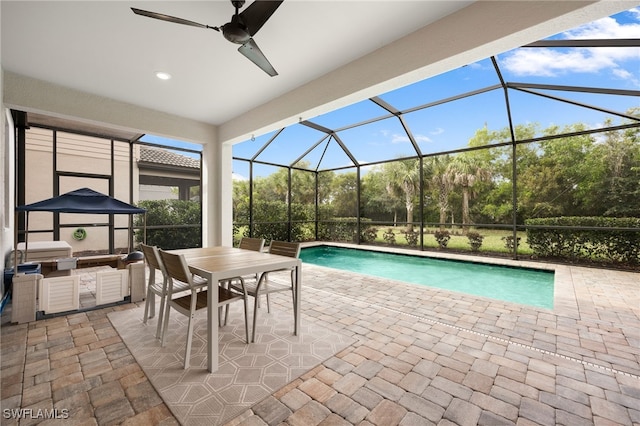 outdoor pool with ceiling fan, glass enclosure, a patio area, outdoor dining space, and an outdoor kitchen