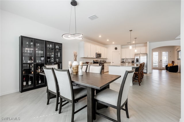 dining area with recessed lighting, visible vents, arched walkways, and french doors