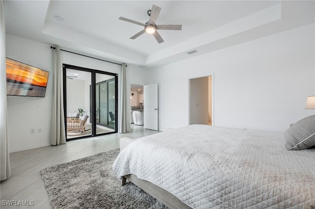 bedroom featuring a raised ceiling, access to outside, visible vents, and tile patterned floors