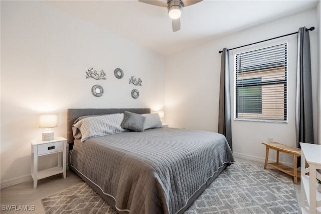 bedroom featuring light tile patterned floors, a ceiling fan, and baseboards